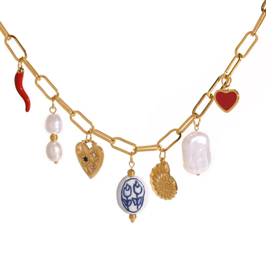 Gold chain necklace with various charms on a white background