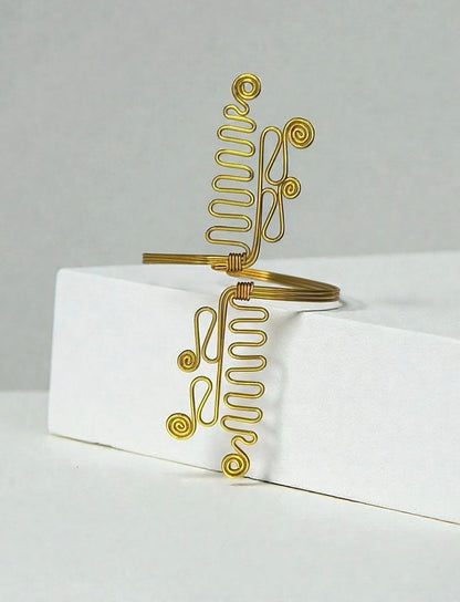 A Brass wire wrap cuff bracelet with spiral and coiled decorative details